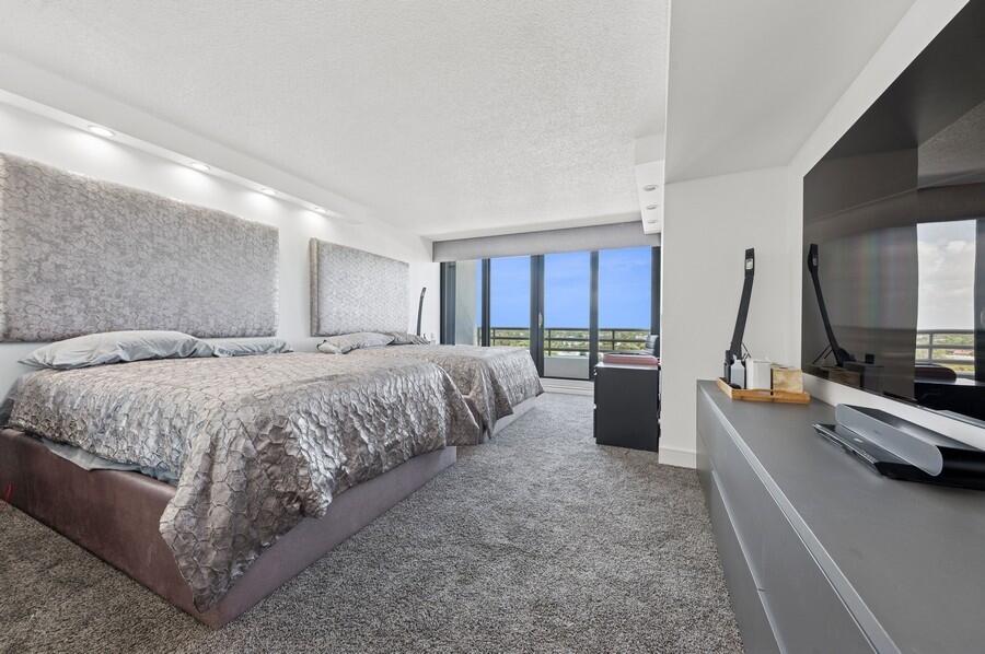 1400 South Ocean Boulevard, Unit 1004 Boca Raton, FL 33432 - Photo 11 of 55 a spacious bedroom with a large bed and a flat screen tv