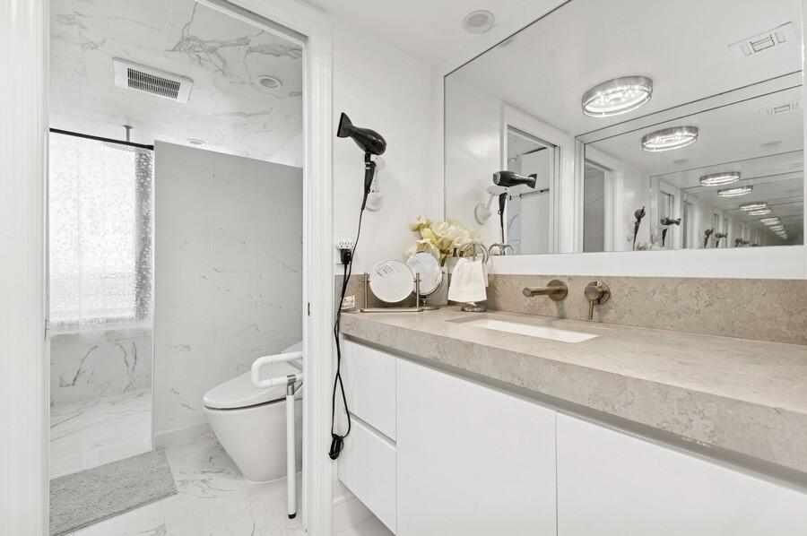 1400 South Ocean Boulevard, Unit 1004 Boca Raton, FL 33432 - Photo 16 of 55 a bathroom with a granite countertop sink a toilet and a shower