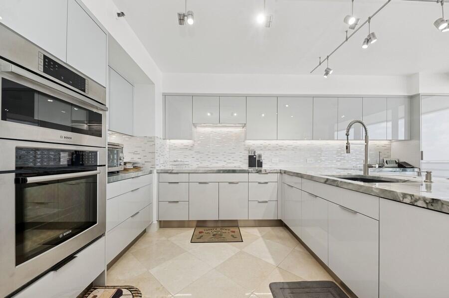 1400 South Ocean Boulevard, Unit 1004 Boca Raton, FL 33432 - Photo 7 of 55 a kitchen with granite countertop stainless steel appliances sink and cabinets