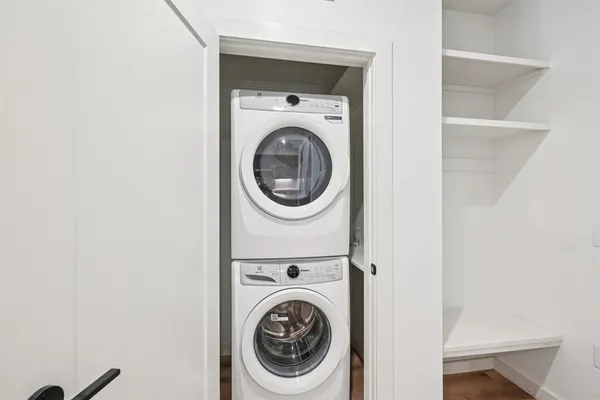 an empty room with wooden floor and fan