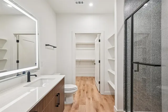 a bathroom with a double vanity sink mirror and toilet
