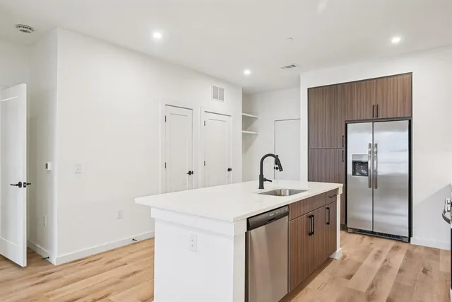 a kitchen with kitchen island a sink stove and refrigerator