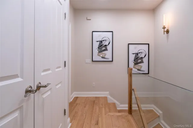 a view of a hallway with wooden floor and closet