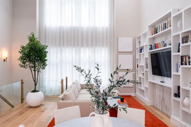 a living room with furniture potted plant and a flat screen tv