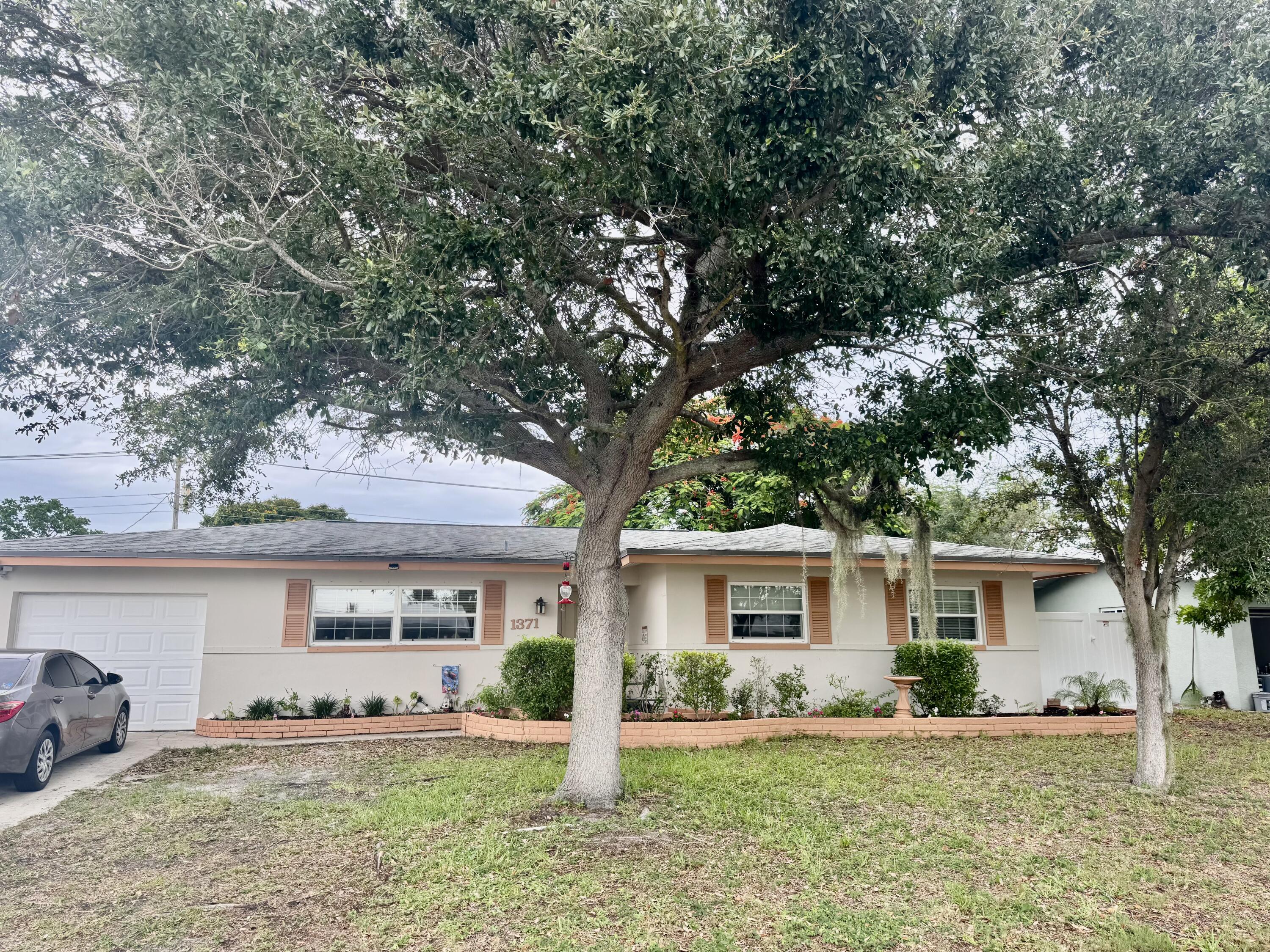 a front view of a house with a yard and trees
