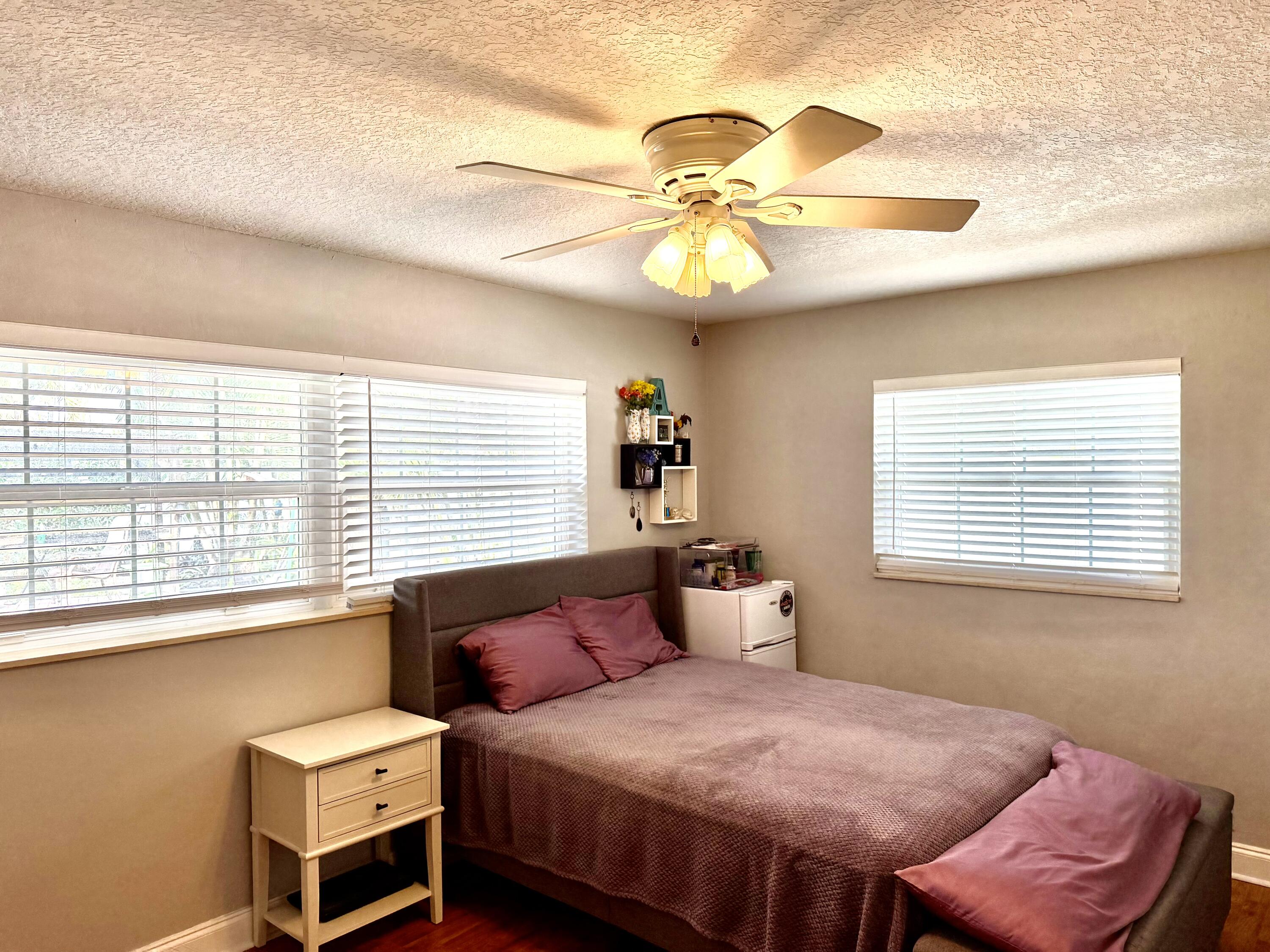 1371 Southwest 4th Street Boca Raton, FL 33486 - Photo 13 of 19 a bedroom with a bed and a chandelier