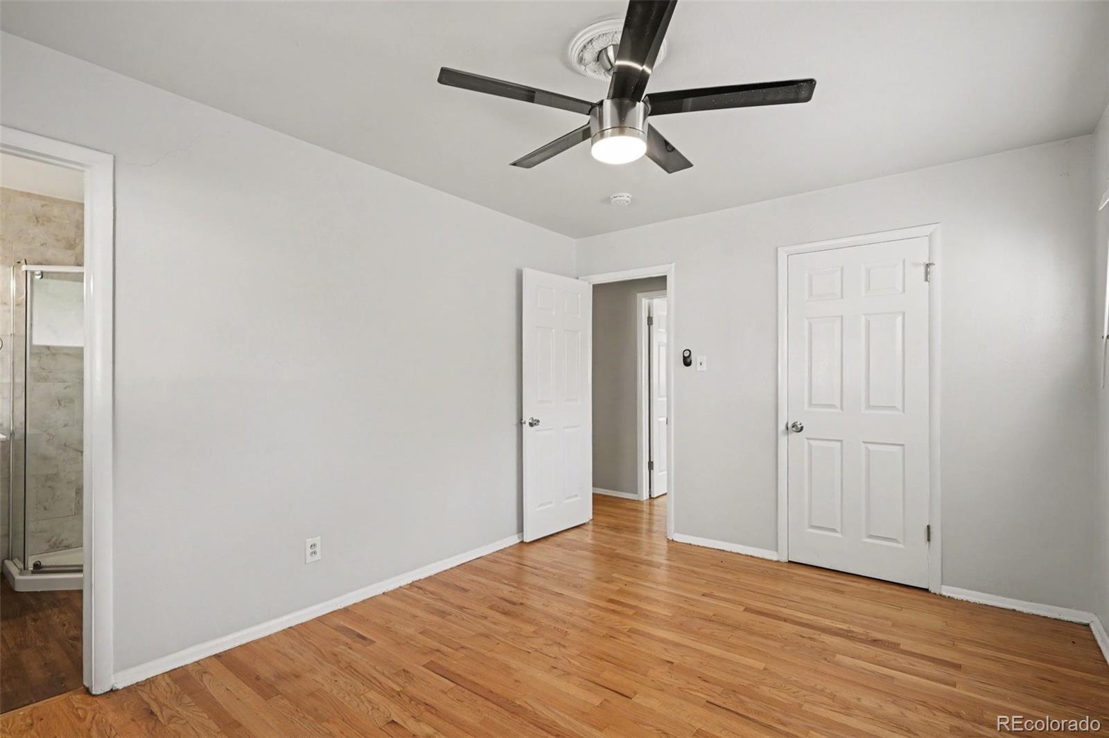 3217 South Stuart Street Denver, CO 80236 - Photo 17 of 29 an empty room with wooden floor fan and windows