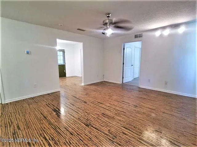 a view of an empty room with wooden floor