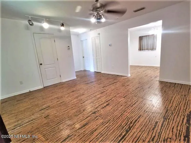 a view of empty room with wooden floor