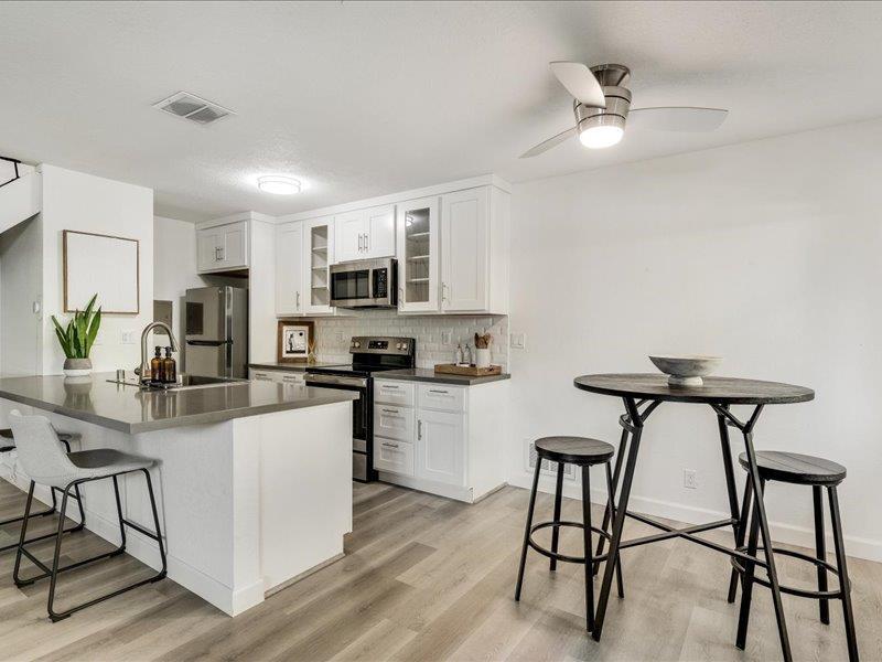 4475 Diamond Street, Unit 3 Capitola, CA 95010 - Photo 11 of 25 a kitchen with stainless steel appliances granite countertop white cabinets and chairs