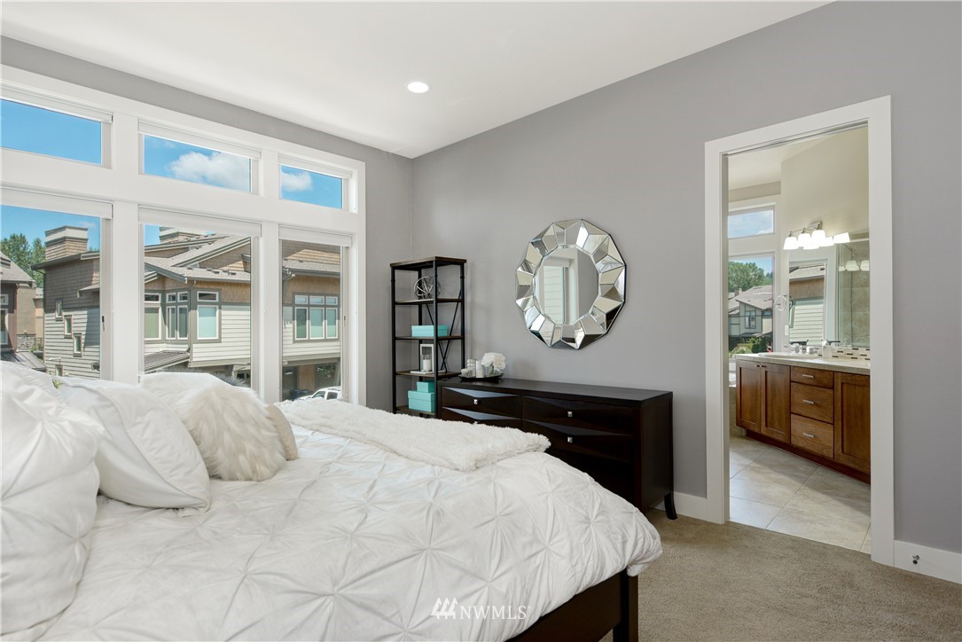 1105 North 41st Place Renton, WA 98056 - Photo 14 of 40 a bedroom with a bed a mirror and a large window with the balcony view