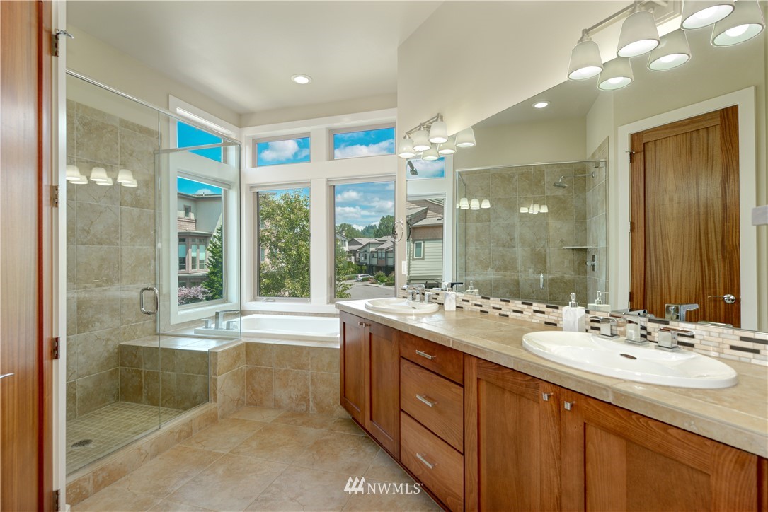 1105 North 41st Place Renton, WA 98056 - Photo 15 of 40 a bathroom with a double vanity sink a large mirror and a bathtub