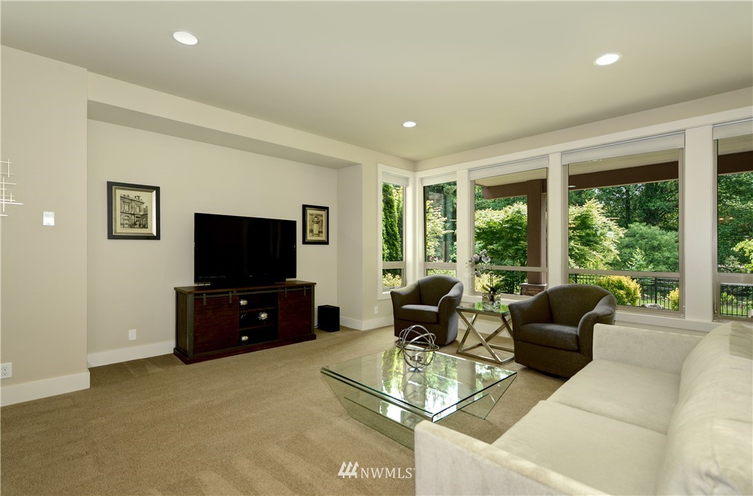 1105 North 41st Place Renton, WA 98056 - Photo 22 of 40 a living room with furniture a flat screen tv and floor to ceiling window