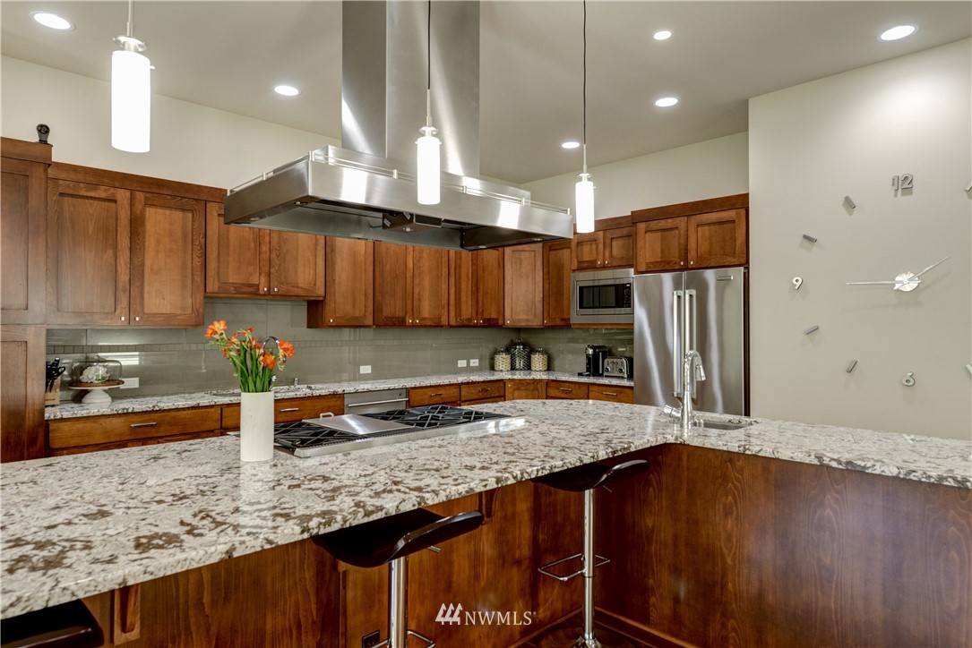 1105 North 41st Place Renton, WA 98056 - Photo 10 of 40 a kitchen with stainless steel appliances granite countertop a sink a stove and a refrigerator
