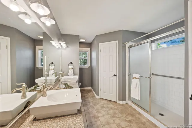 a spacious bathroom with a double vanity sink and a mirror