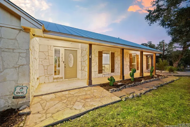 a front view of a house with swimming pool and furniture