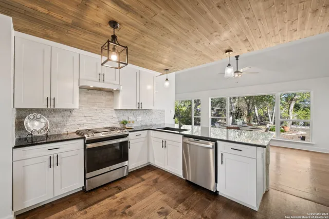a kitchen with stainless steel appliances granite countertop a sink and cabinets