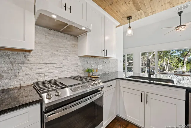 a kitchen with a stove and white cabinets