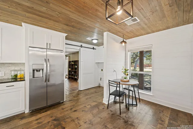 a kitchen with stainless steel appliances kitchen island granite countertop furniture and a refrigerator
