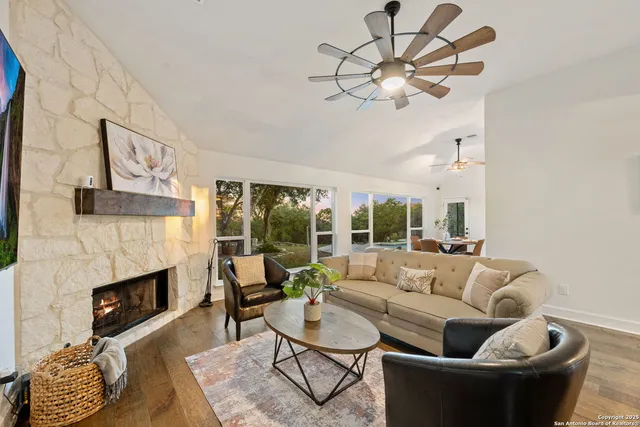 a living room with furniture fireplace and a large window