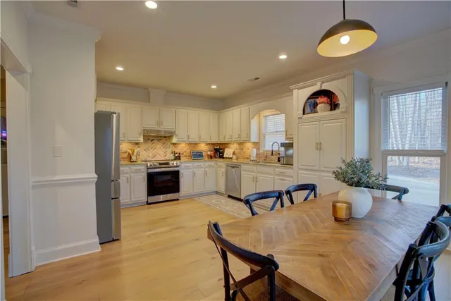 a kitchen with granite countertop white cabinets and white appliances