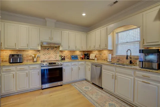 a kitchen with granite countertop white cabinets and sink