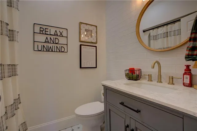 a spacious bedroom with a bed a dresser and a chandelier