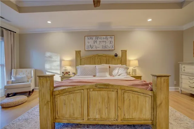 a bedroom with a bed a chair and a chandelier