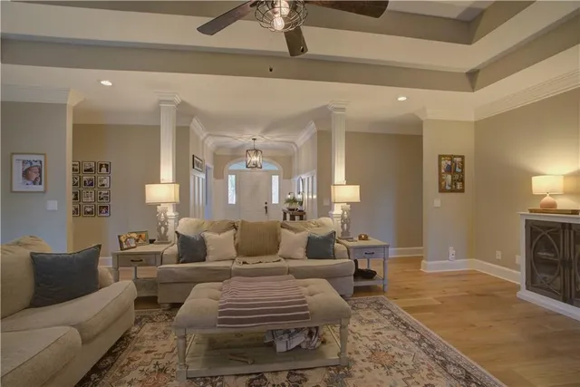 a living room with furniture hard wood floor and a flat screen tv