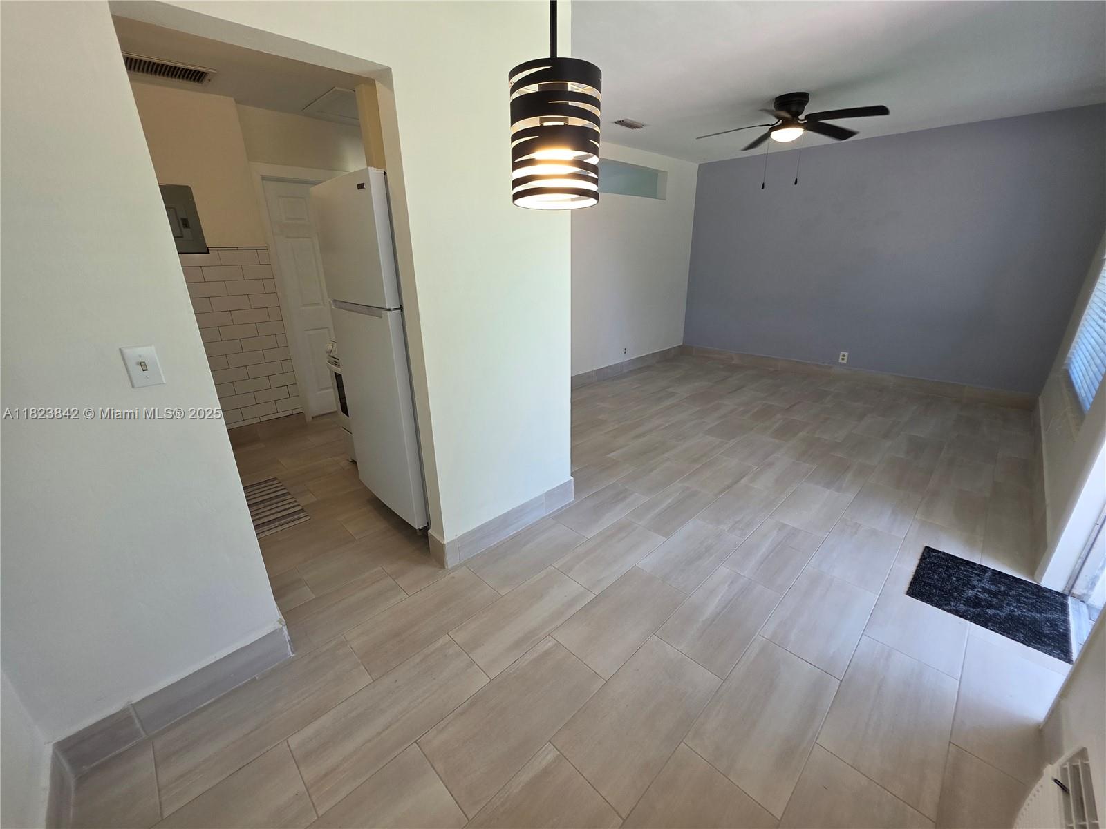 120 Northeast 10th Avenue, Unit 3 Hallandale Beach, FL 33009 - Photo 2 of 11 an empty room with wooden floor and windows