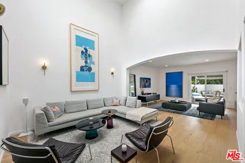 a living room with furniture a large window and a table