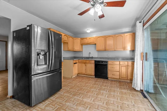 a kitchen with stainless steel appliances granite countertop a refrigerator a sink dishwasher a stove with wooden cabinets