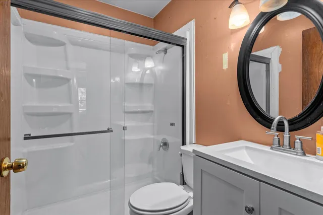 a bathroom with a sink a toilet and a mirror