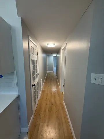 a view of hallway with wooden floor
