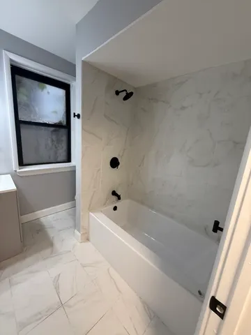 a bathroom with a bathtub and a shower