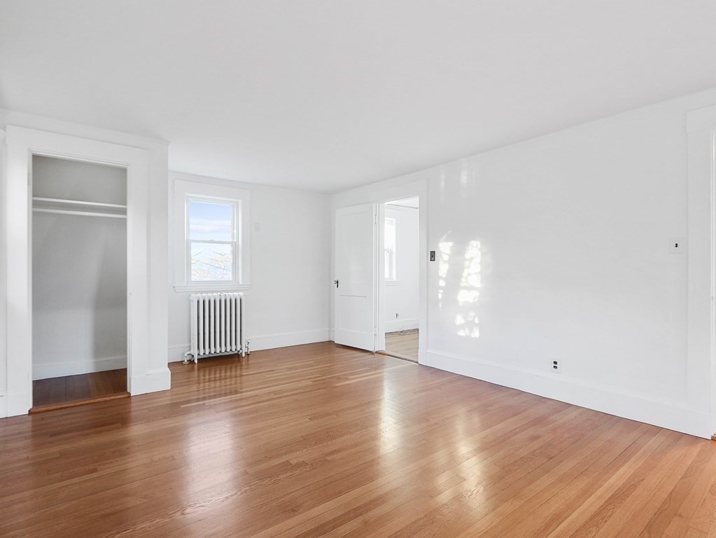 122 Albemarle Road Newton, MA 02460 - Photo 16 of 28 an empty room with wooden floor & windows and bathroom