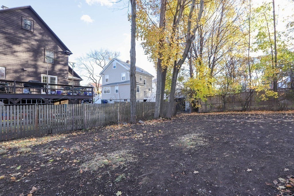 122 Albemarle Road Newton, MA 02460 - Photo 26 of 28 a view of a backyard with large trees and wooden fence