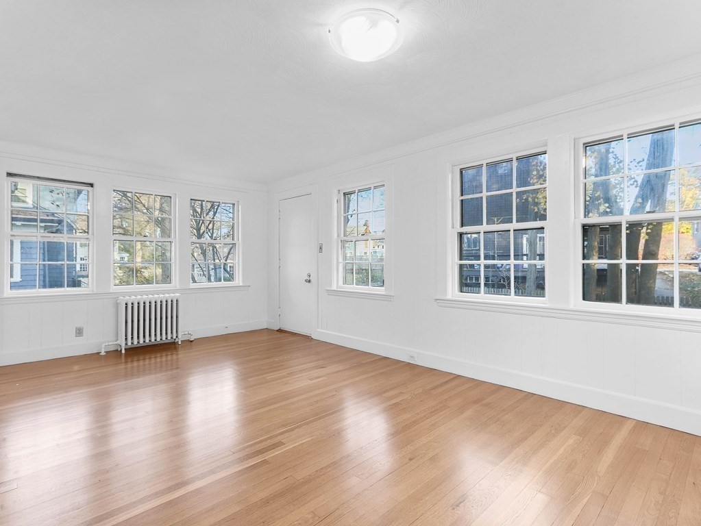 122 Albemarle Road Newton, MA 02460 - Photo 7 of 28 a view of an empty room with wooden floor and windows