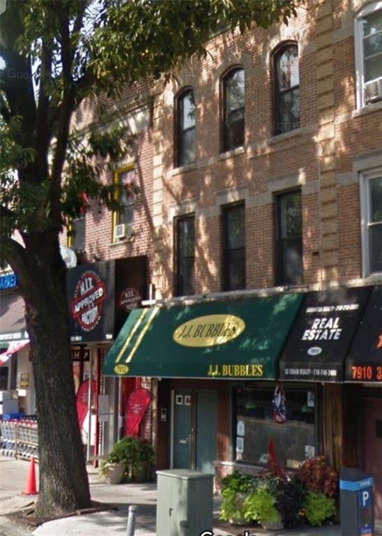 a view of a cafe with table and chairs under an umbrella