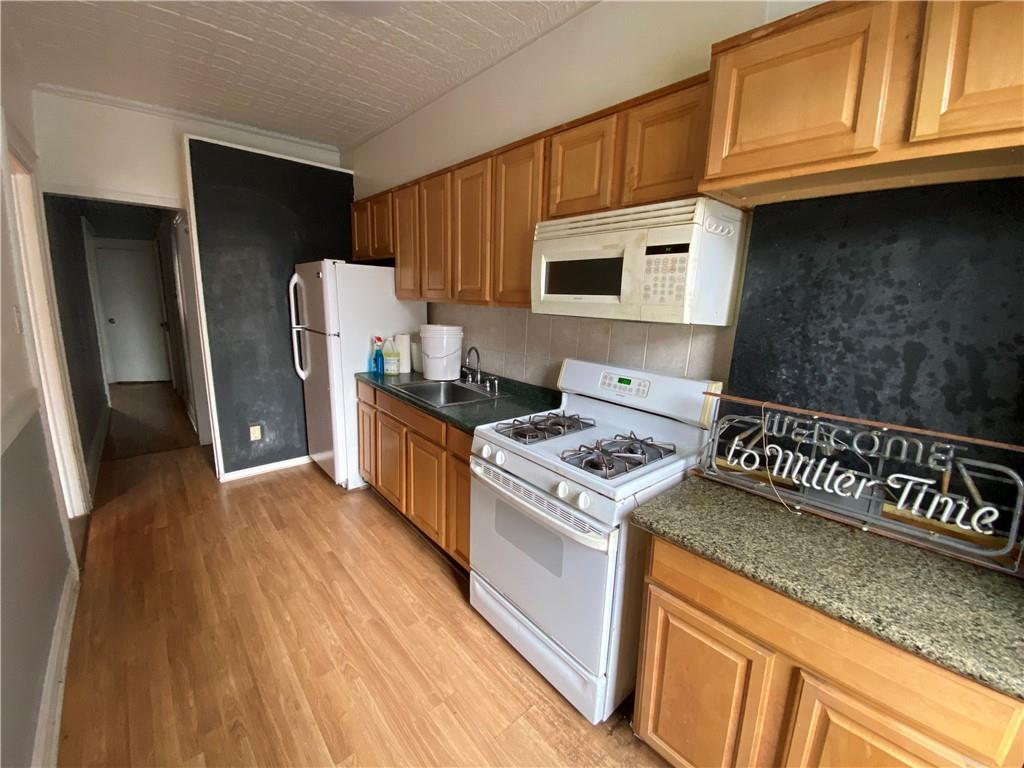 7912 3rd Avenue Brooklyn, NY 11209 - Photo 12 of 18 a kitchen with stainless steel appliances granite countertop a refrigerator a stove and a sink