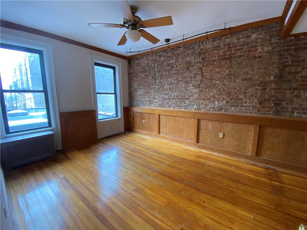 7912 3rd Avenue Brooklyn, NY 11209 - Photo 3 of 18 a view of empty room with wooden floor and fan