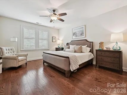 a bedroom with a bed and furniture with wooden floor