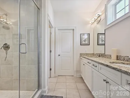a spacious bathroom with a granite countertop sink a mirror and a shower