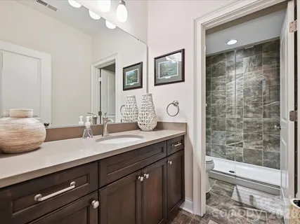 a bathroom with a sink a toilet and shower