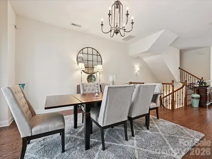 a view of a dining room with furniture a chandelier and wooden floor