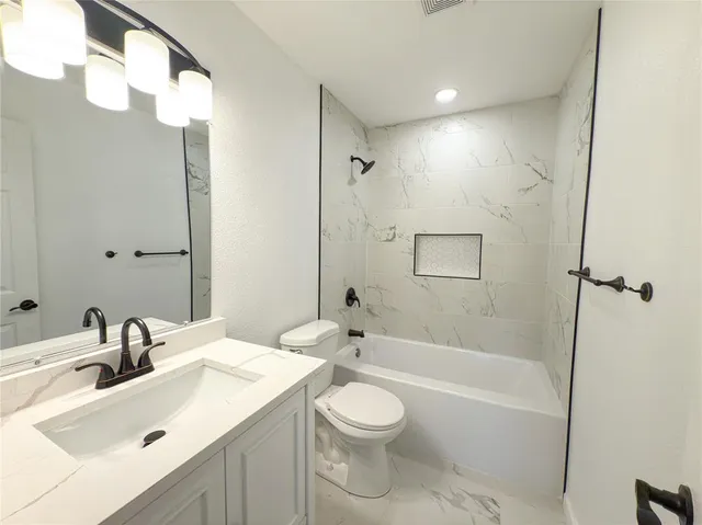 a bathroom with a sink toilet vanity and shower