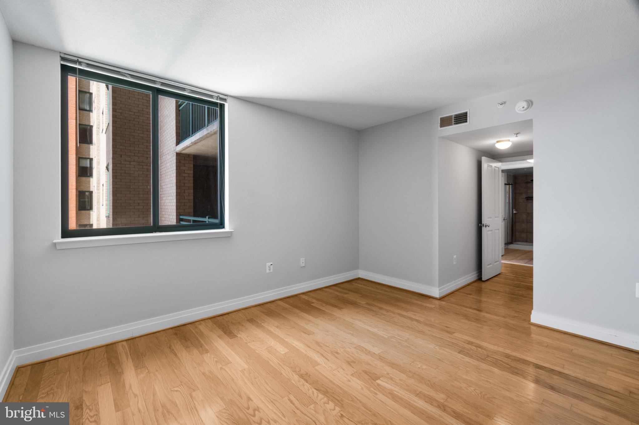 414 Water Street, Unit 1315 Baltimore, MD 21202 - Photo 21 of 30 a view of an empty room with wooden floor and a window