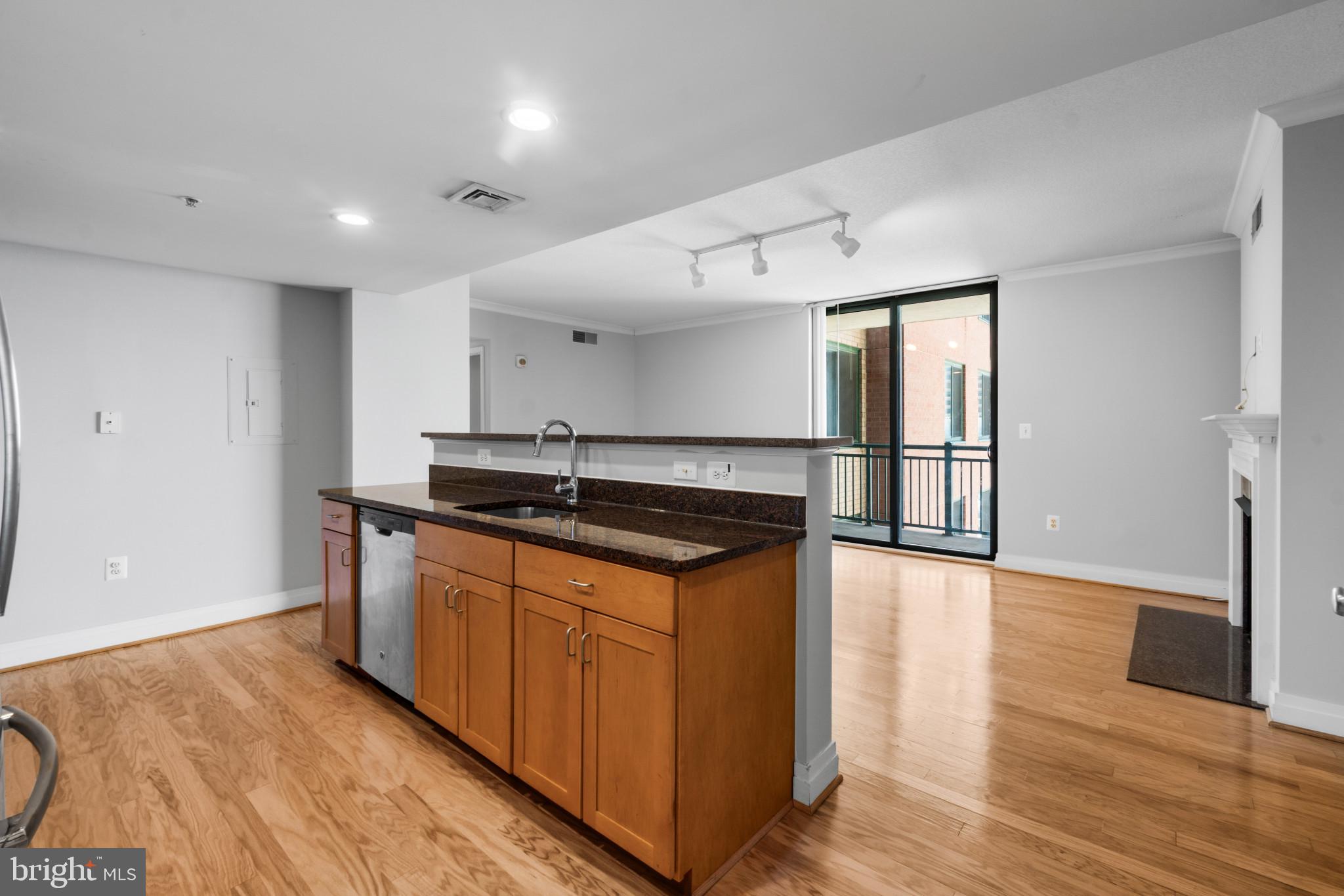 414 Water Street, Unit 1315 Baltimore, MD 21202 - Photo 5 of 30 a kitchen with granite countertop a sink and a stove top oven