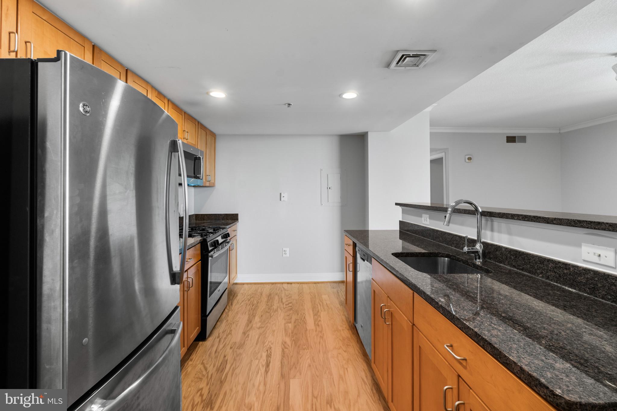 414 Water Street, Unit 1315 Baltimore, MD 21202 - Photo 6 of 30 a kitchen with stainless steel appliances granite countertop a refrigerator and a sink