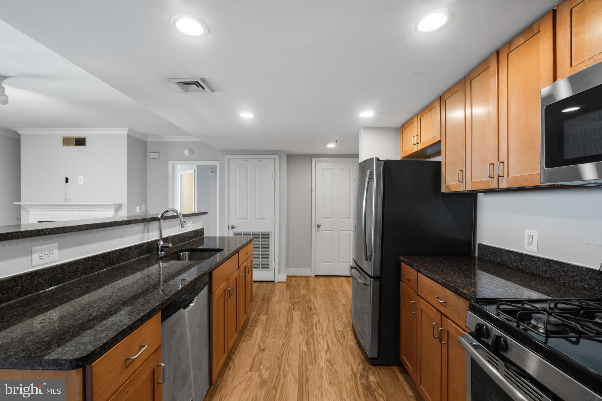 414 Water Street, Unit 1315 Baltimore, MD 21202 - Photo 9 of 30 a kitchen with stainless steel appliances granite countertop a stove a sink and a refrigerator